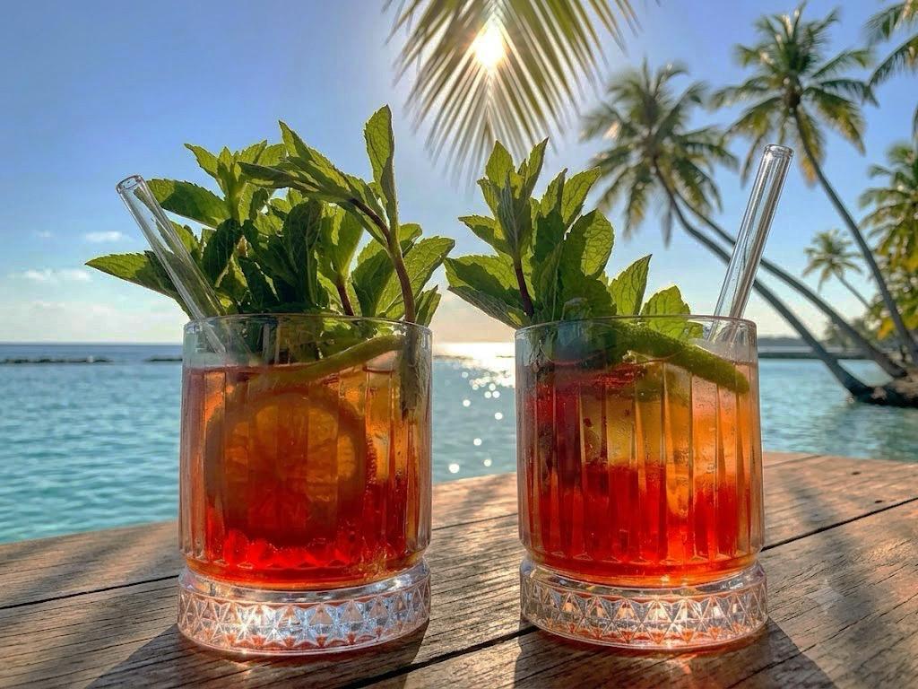 Zwei SPIRULI Drinks am Strand mit Minze und Glasstrohhalmen